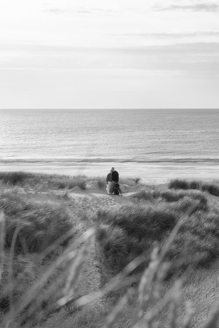 Hundefotografie in Blåvand: Paar mit Hund auf Dünenweg vor Nordsee, Schwarz-Weiß